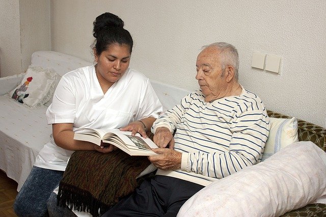 women showing elderly man a book